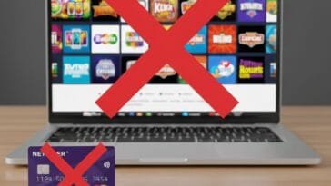 Tietokoneen näytöllä nettikasinosivusto ja suuri punainen rasti, etualalla Neteller Net+ -kortti punaisella rastilla – kuva symboloi Neteller-maksujen estämistä rahapelisivustoilla.