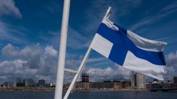 Suomen lippu Helsingin kaupunkimaiseman edessä