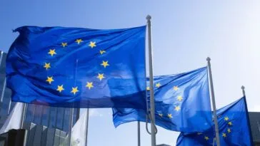 EU-liput liehuvat Brysselissä — EU:n nettirahapelivero on nostettu osaksi vuosien 2028–2034 budjettineuvotteluja, ja toteutuessaan se nostaisi Suomen rahapeliverokannan 25 prosenttiin