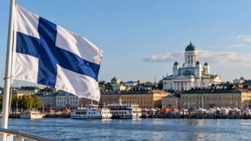Suomen lippu liehuu Helsingin Kauppatorin ja Tuomiokirkon edustalla.